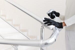 hands-with-gloves-disinfecting-hand-rail